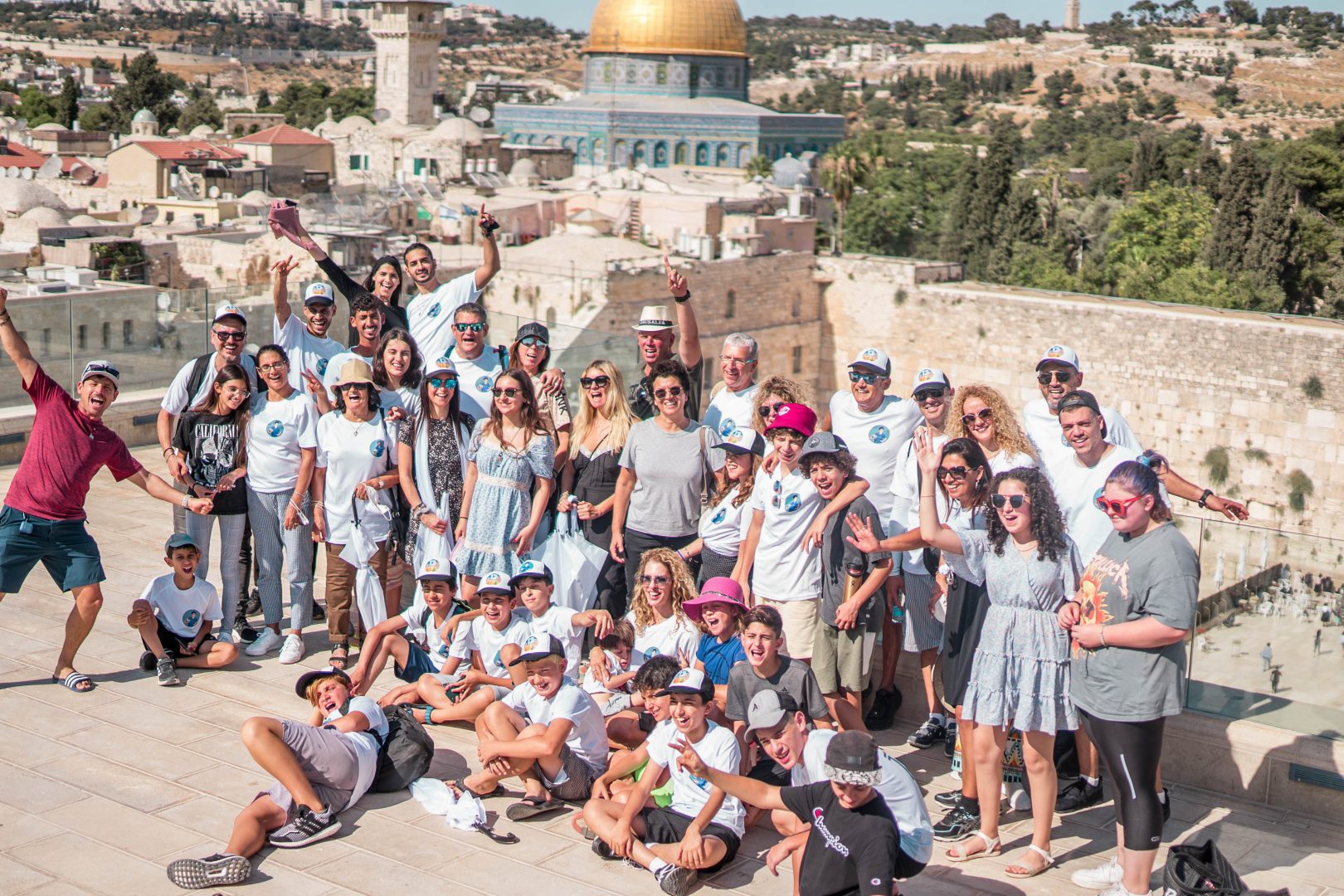 קבוצה של אנשים באירוע בר מצווה מול נוף הכותל של ירושלים