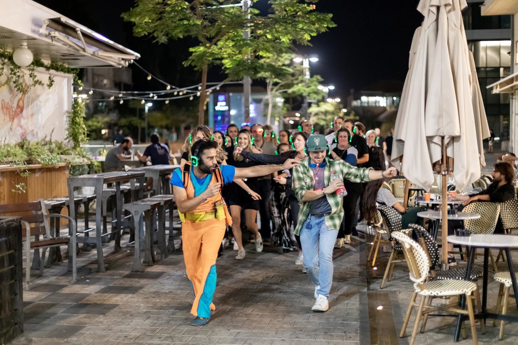 קבוצה רוקדת במסיבת אוזניות של זוזו גורו בסיור בתל אביב