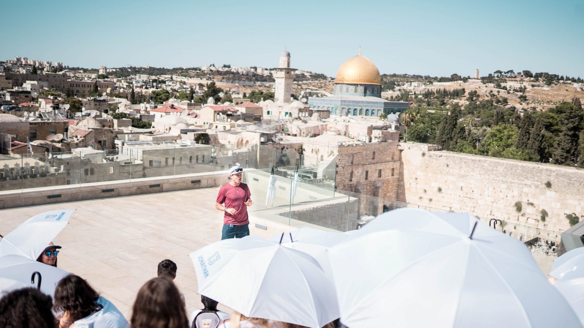 ארז לנדאו מדריך טיולים בכיר מדבר אל מול קבוצה בגג מול הכותל בירושלים