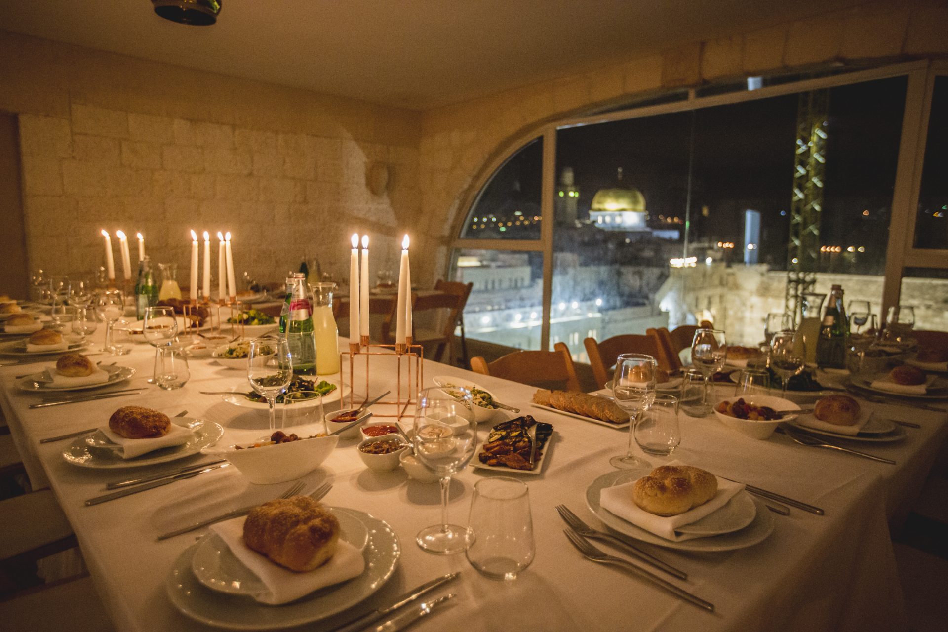 שולחן ארוחת ערב ונרות דולקים אל מול הנוף של ירושלים